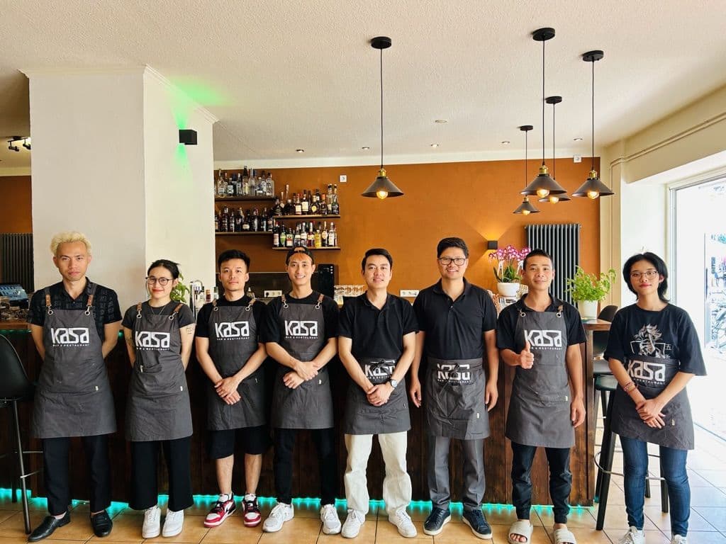 Mitarbeiter mit KASA-Schürzen an der Bar des Restaurants