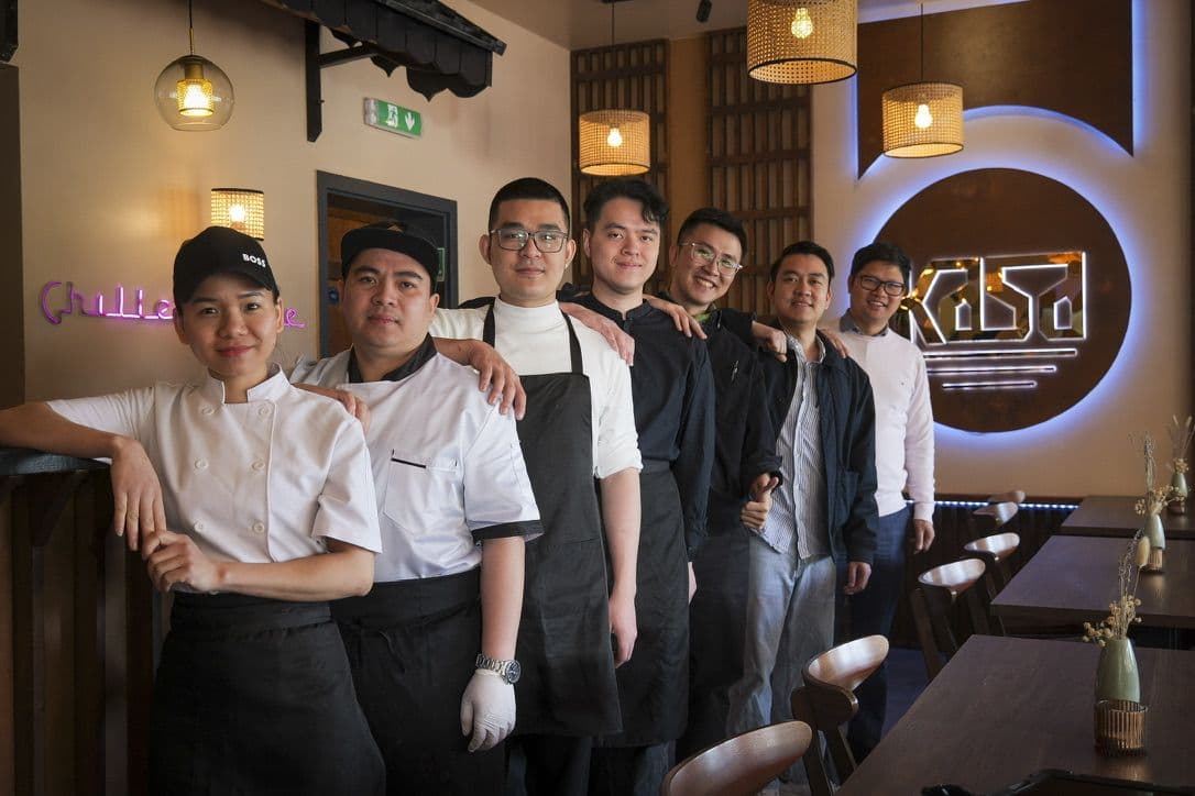 Sieben Mitarbeiter in Koch- und Servicekleidung im Restaurant in Hamm