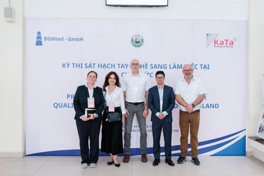 Die Delegation aus Deutschland gemeinsam mit KATA vor dem Banner der Prüfung in Hanoi